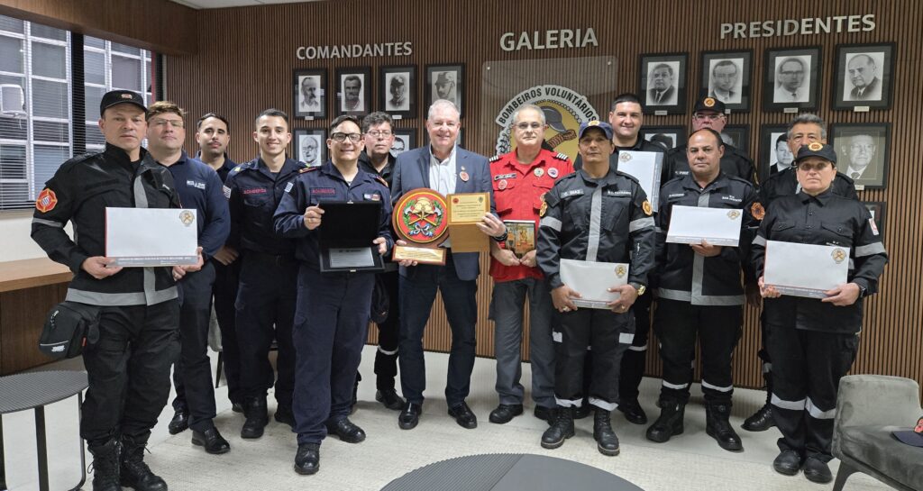 Presidente Ivan Frederico Hudler (no centro, de cinza) entregou relatório de atividades e o livro dos 30 anos da ABVESC para a comitiva e recebeu um brasão da Direção Nacional de Bombeiros do Uruguai